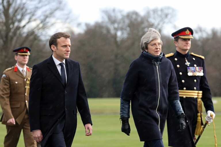 French President Emmanuel Macron (2nd L) and Britain's Prime Minister Theresa May (2nd R) arrive to review an honour guard at the Royal Military Academy Sandhurst, west of London on January 18, 2018. President Macron will take part in a Franco-British summit.