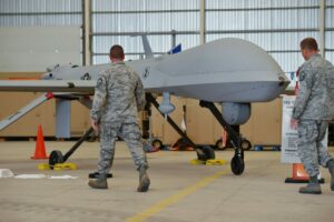 Soldiers pass a US unmanned remotely piloted aircraft MQ-1 Predator during a guest day at Lielvarde airbase, south-east of Riga, Latvia, on 8 September 2015. Latvia had confirmed a week before that two US Army Predator surveillance drones and 70 airmen had deployed to the base for a training mission. The name Predator may have been inspired by the movie featuring Arnold Schwarzenegger.