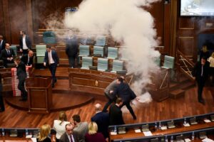 Kosovo's lawmakers react after opposition members released a teargas canister inside the country's parliament in Pristina on March 21, 2018 before a vote for an agreement to ratify or not a border demarcation deal signed in 2015 with Montenegro.